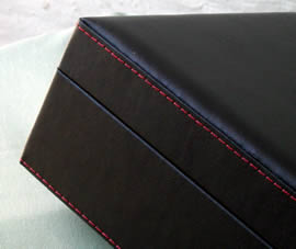 black leatherette with a padded top and red topstitching